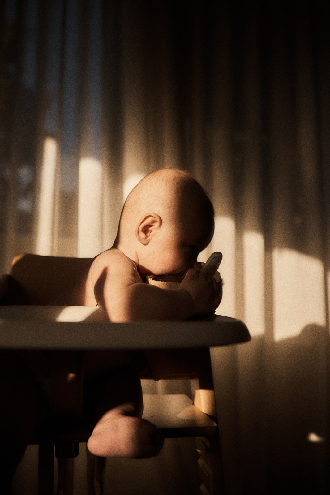 Baby in a high chair at sunset, sheer curtains glowing behind — from the Vestige guide